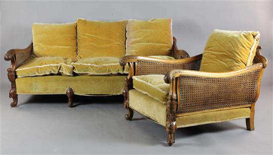 An early 20th century foliate carved walnut three piece bergere suite, settee W.6ft D.3ft 6in. H.2ft 6in.